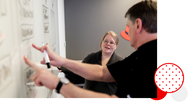 Employés Red Hat travaillant ensemble devant un tableau blanc